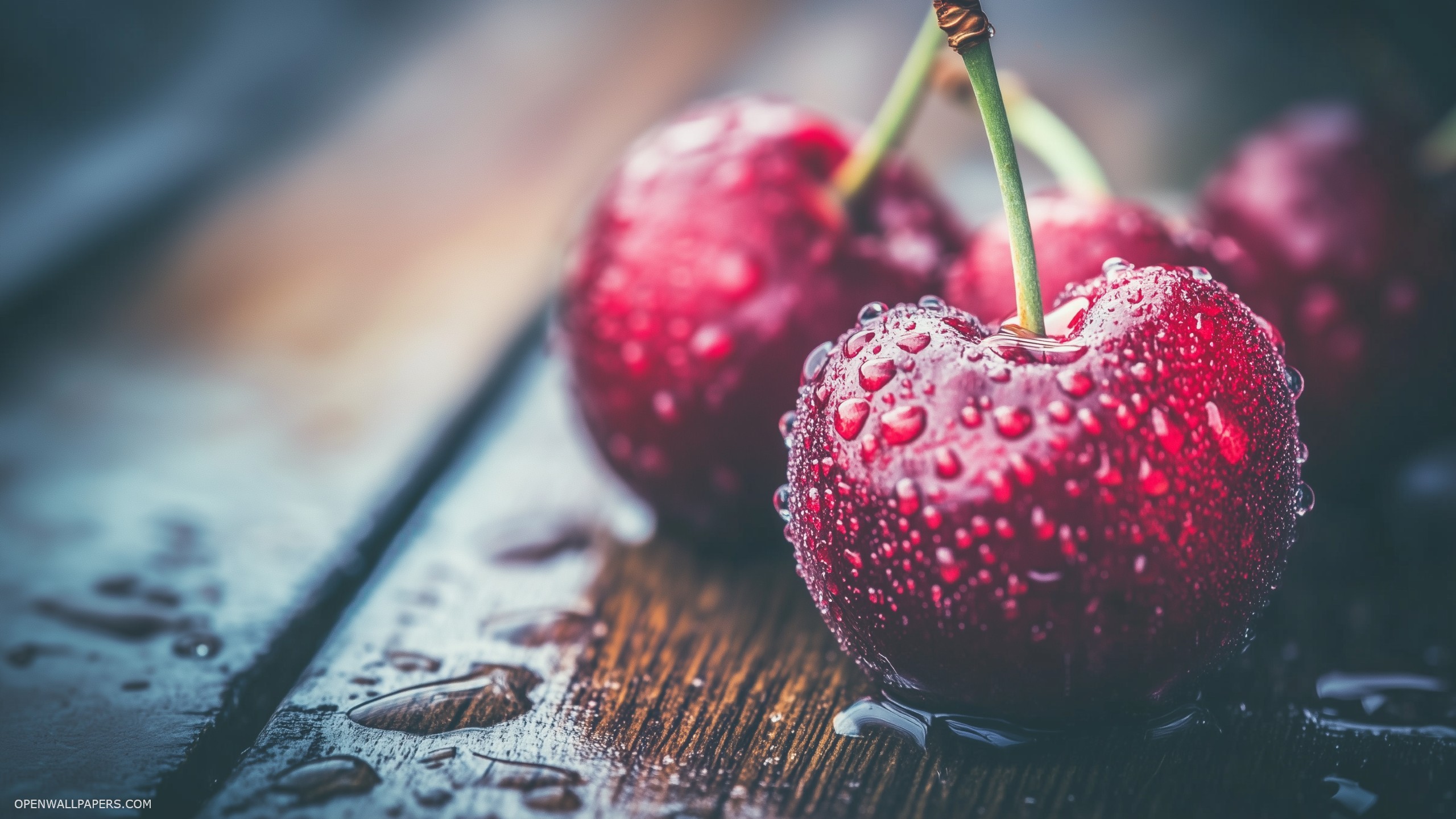 A close up of fresh ripe cherries with vibrant red color glistening with morning dew on a rustic wooden surface 2560x1440